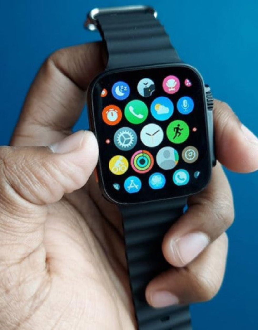 Smartwatch with a colorful display held in a hand against a blue background