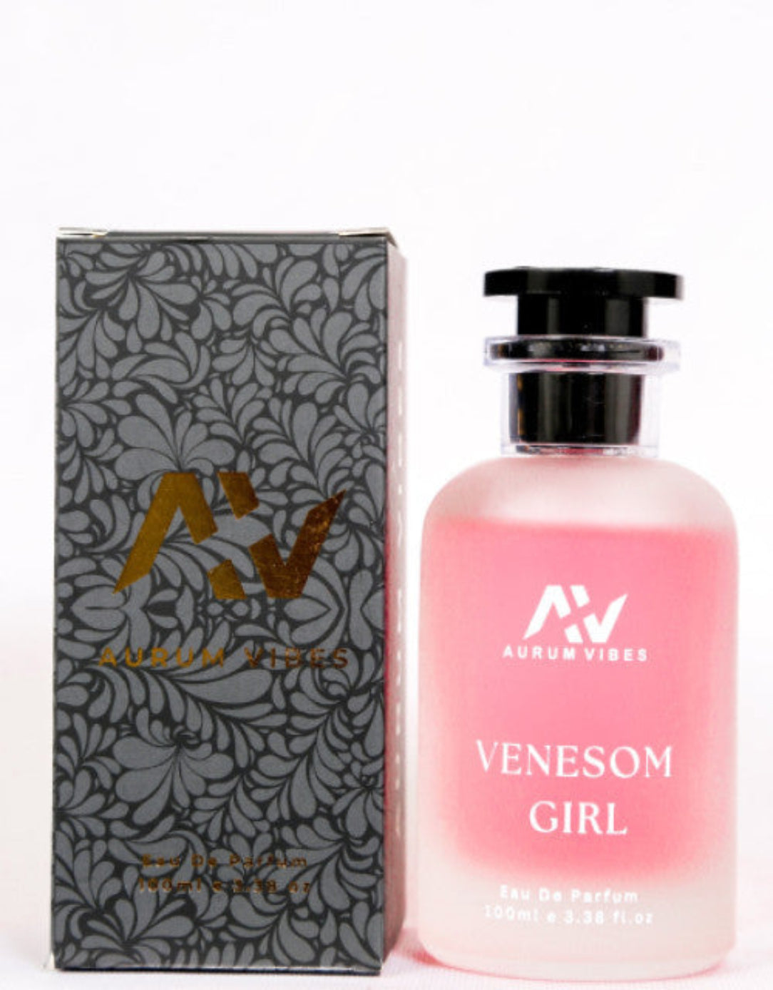 Pink perfume bottle with black cap and floral packaging on a white background