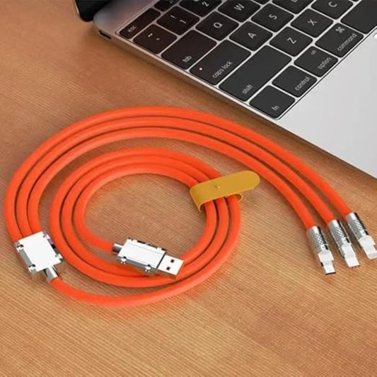 Orange cable with multiple connectors on a wooden surface next to a laptop.