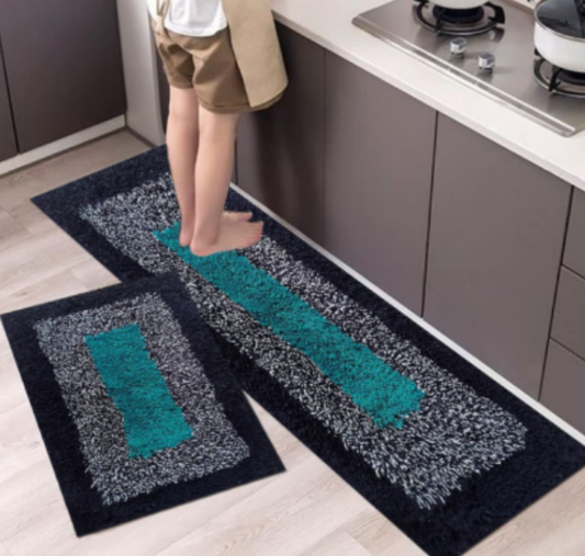 Two kitchen mats with teal and gray pattern on a wooden floor.
