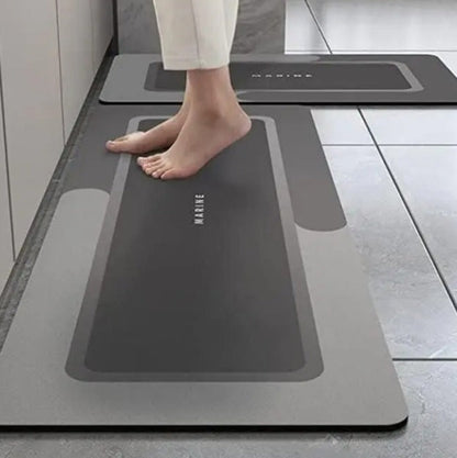 Person stepping onto a gray anti-fatigue mat with 'Marime' branding in a kitchen setting.