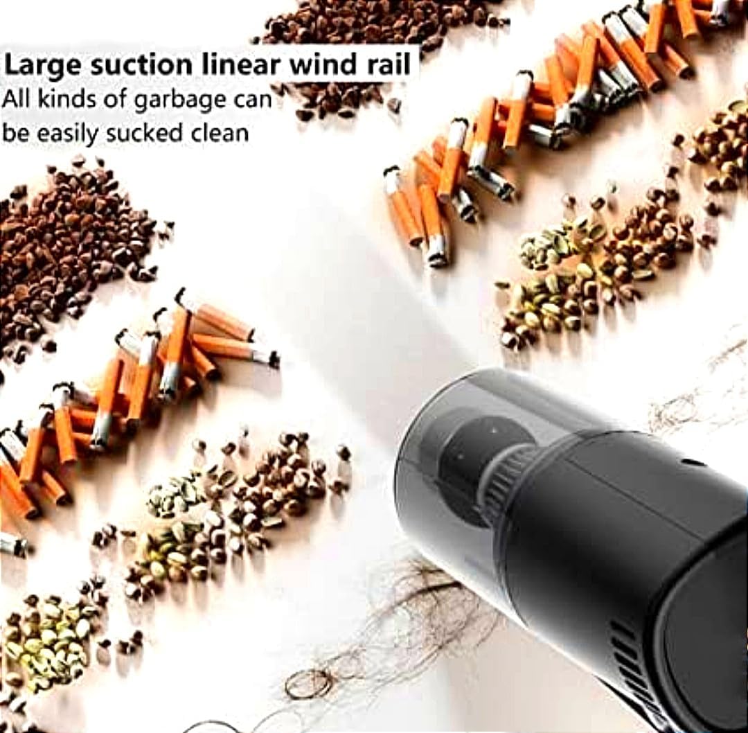 Black handheld vacuum cleaning up scattered trash on a light background