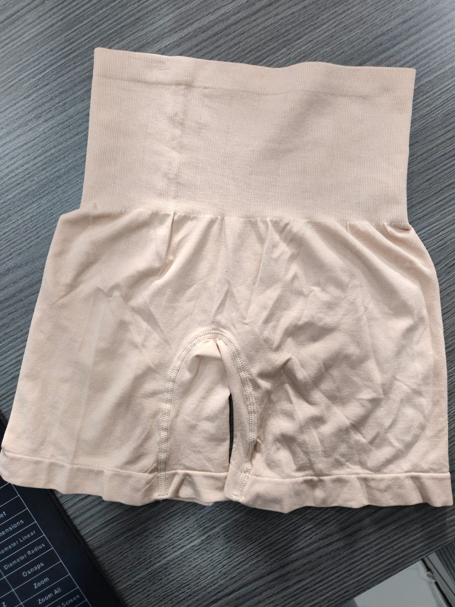 Beige high-waisted underwear on a dark textured surface