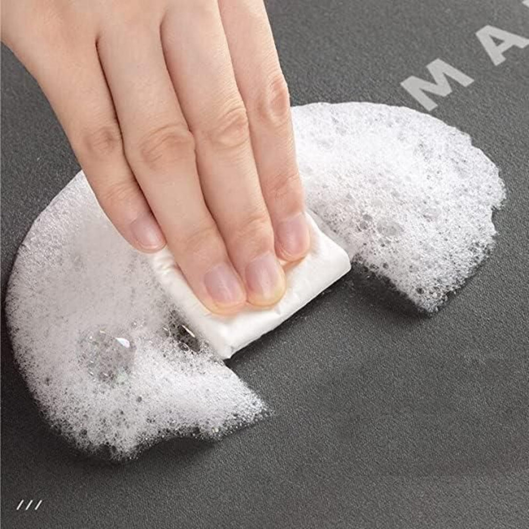 Hand using a soapy sponge on a dark surface with 'MAX' branding.