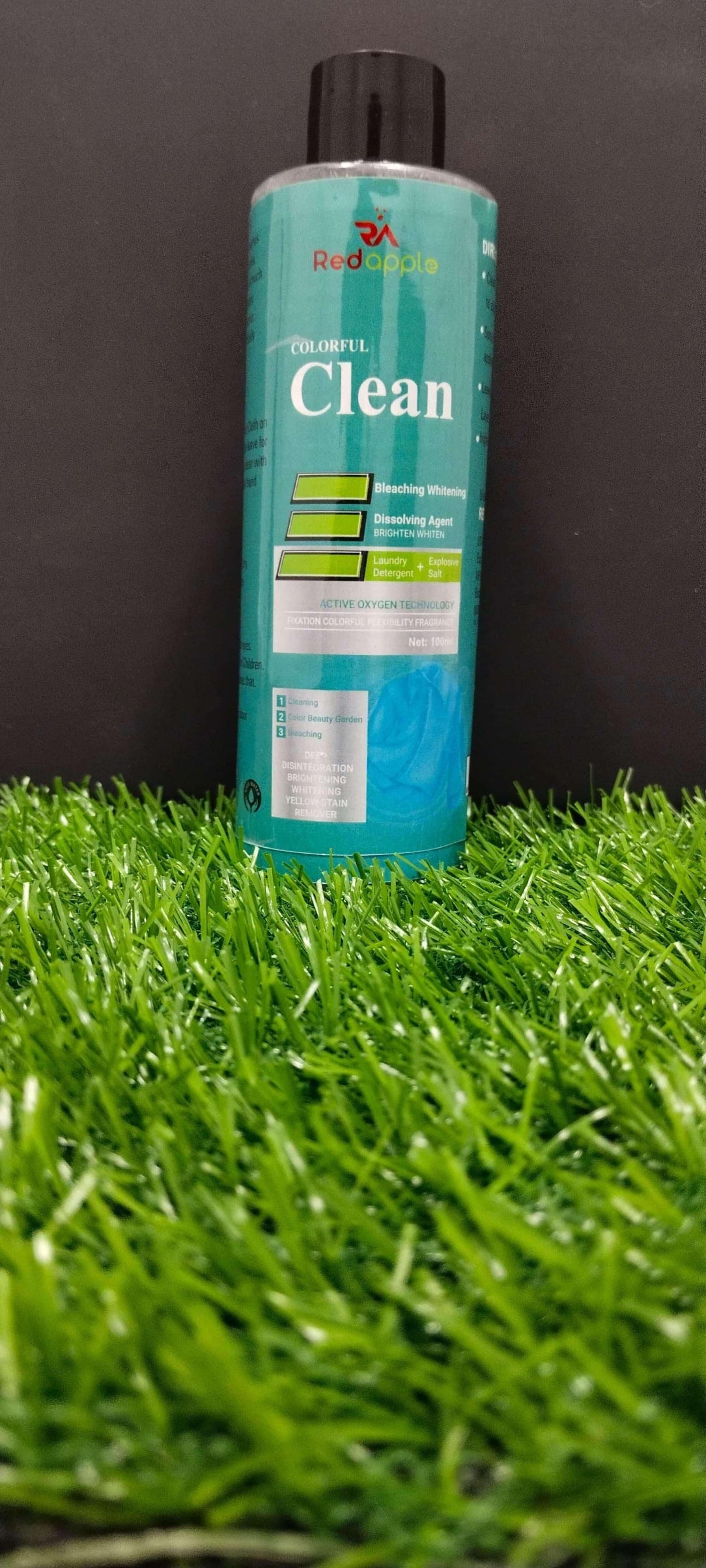Bottle of 'Clean' cleaning solution on artificial grass with a black background