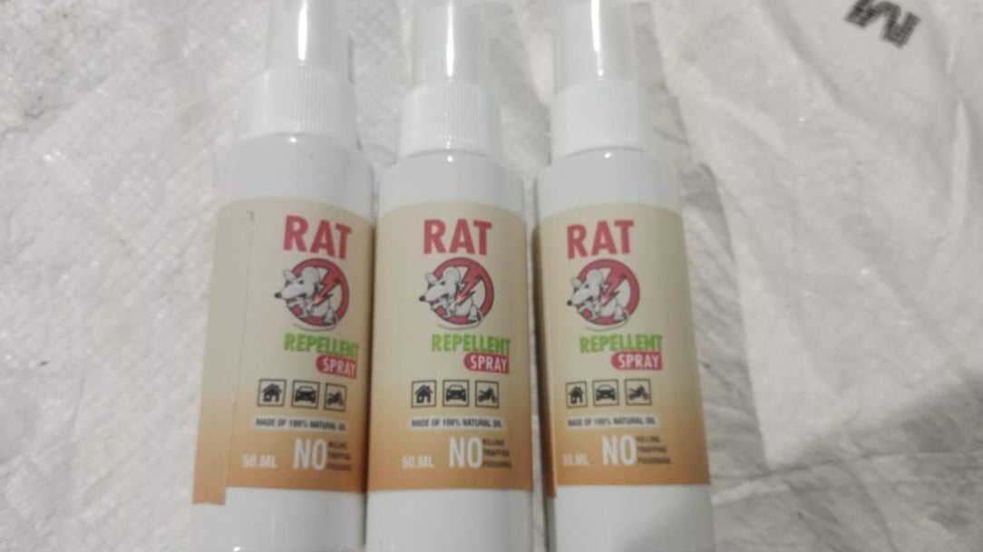 Three bottles of rat repellent spray on a textured white background