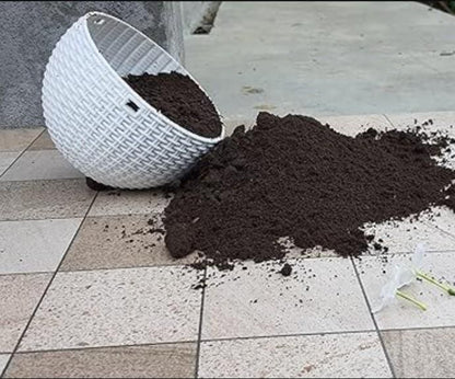 White woven basket with soil spilling onto a tiled floor