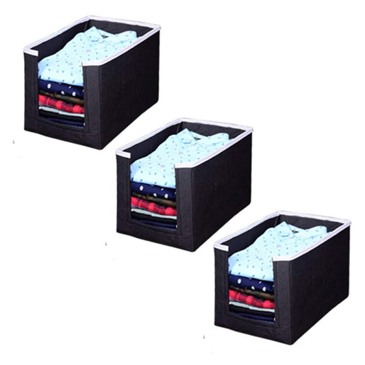 Three black fabric storage cubes with clothes on a white background