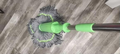 Mop with a green handle cleaning a wooden floor
