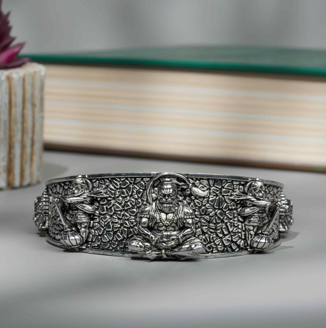 Silver bracelet with intricate designs on a gray surface