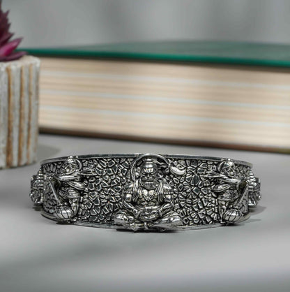 Silver bracelet with intricate designs on a gray surface