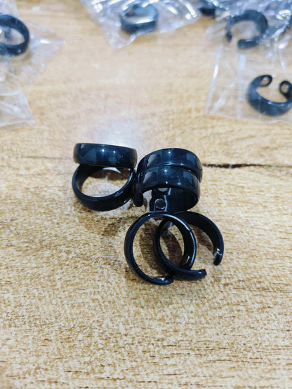 Black earplugs on a textured surface with packaging in the background