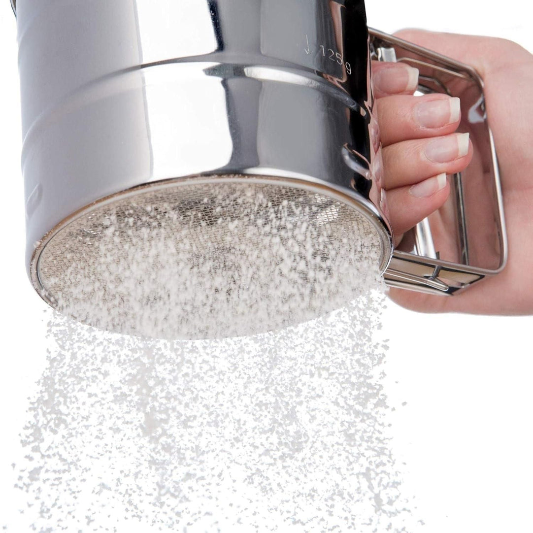 Metallic shower head being held by a hand with a white background