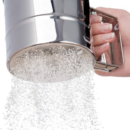 Metallic shower head being held by a hand with a white background