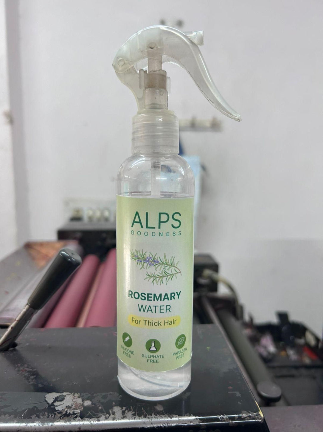Bottle of Alps Goodness rosemary water spray on a desk