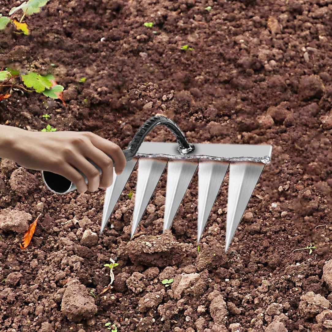 Person using a garden rake on soil