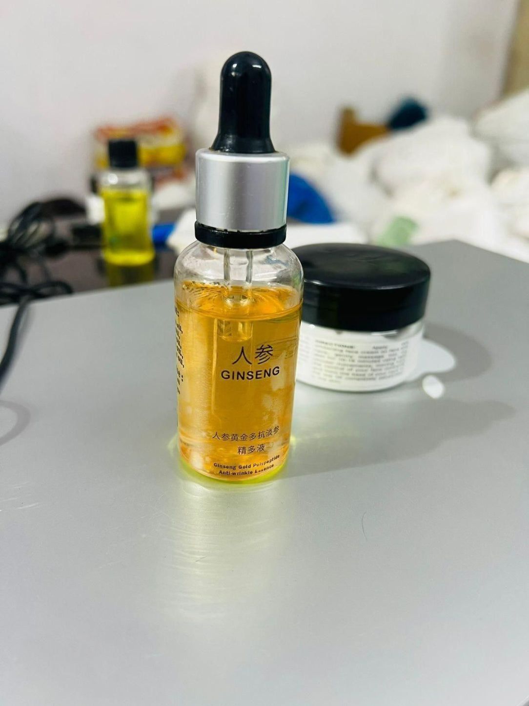 Bottle of Ginseng extract with a dropper on a white surface