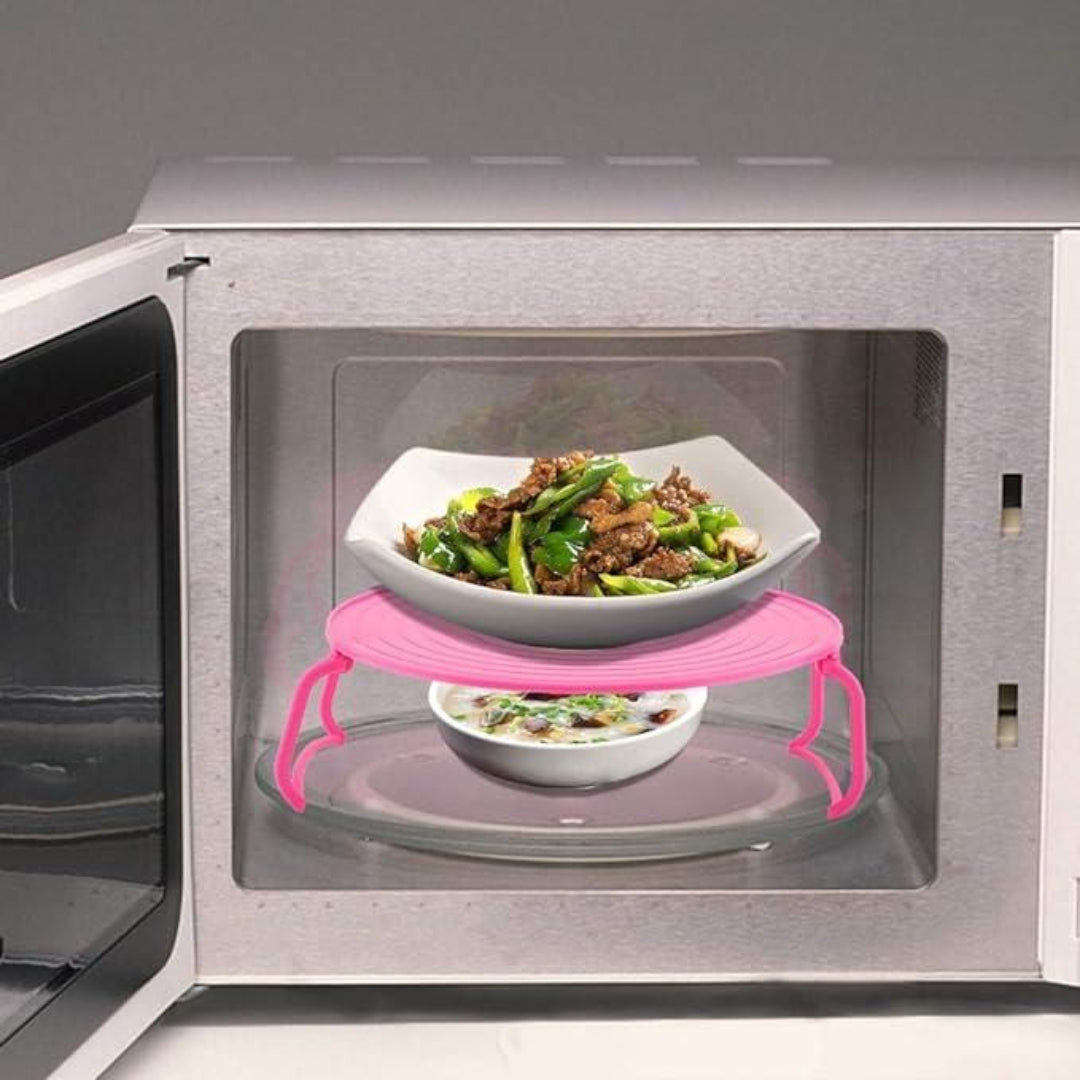 Microwave with a pink rack holding two bowls of food inside.