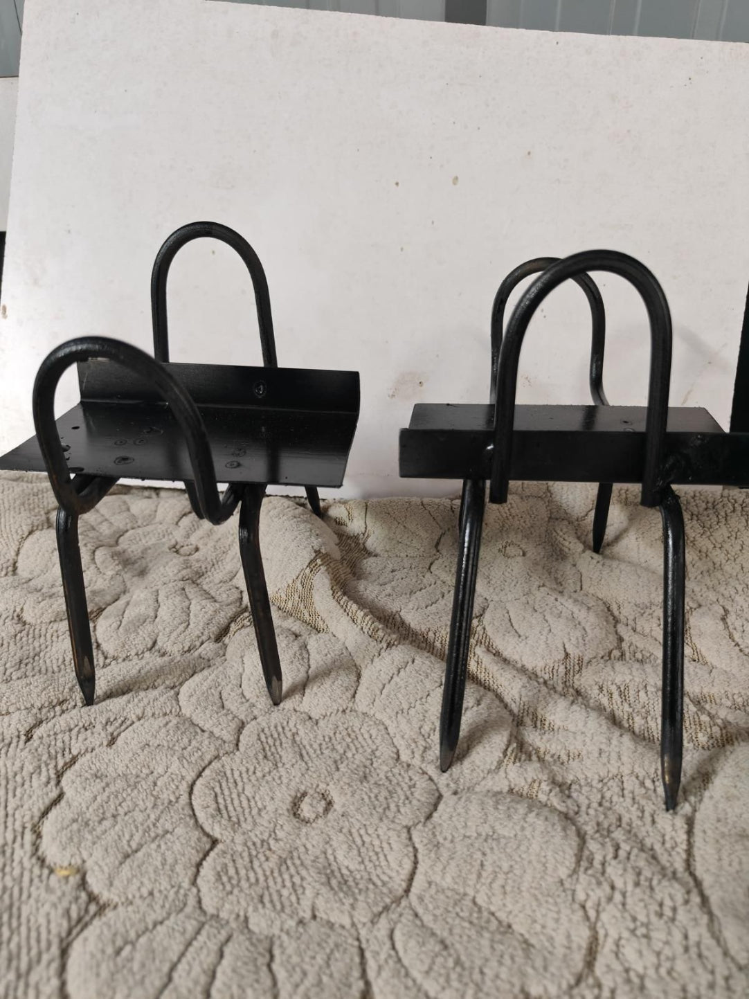 Two black metal chairs on a textured white surface