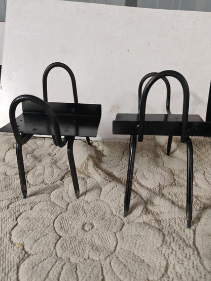 Two black metal chairs on a textured white surface