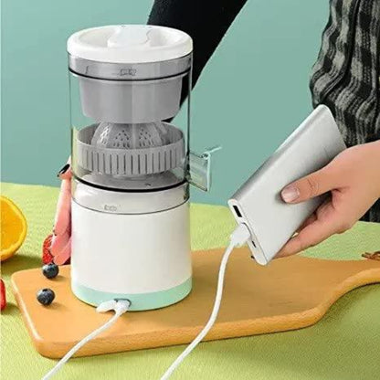 White and gray portable juicer on a wooden board with a power bank plugged in, against a green background.