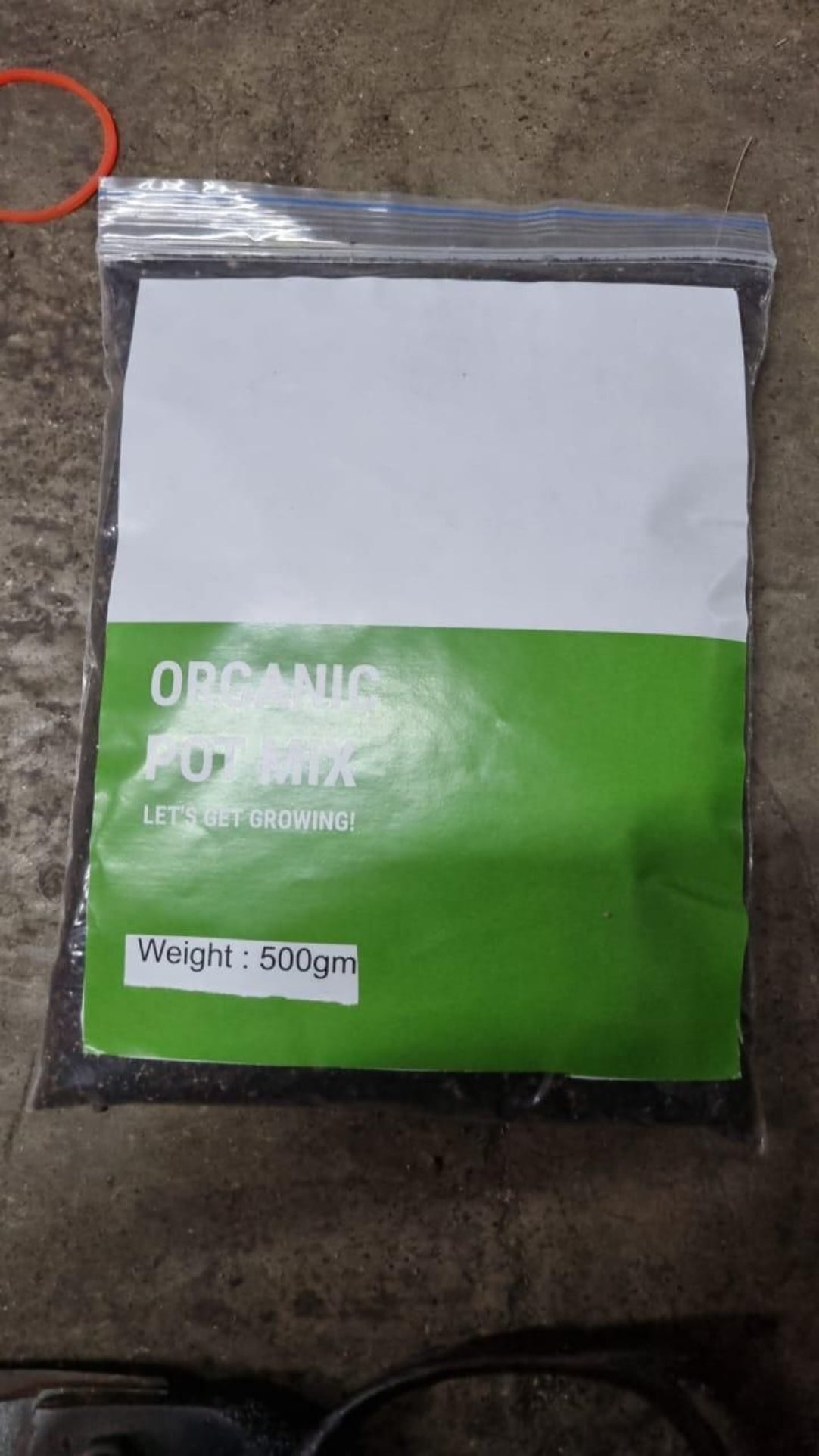 Bag of organic potting mix with visible branding on a concrete surface