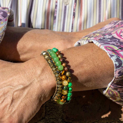 Close-up of a person's legs with colorful bracelets on a striped background
