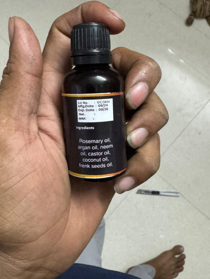 Hand holding a bottle of essential oil with a white background