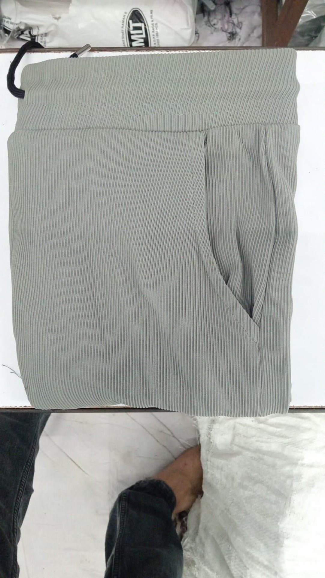 Gray striped pants on a hanger with a white background