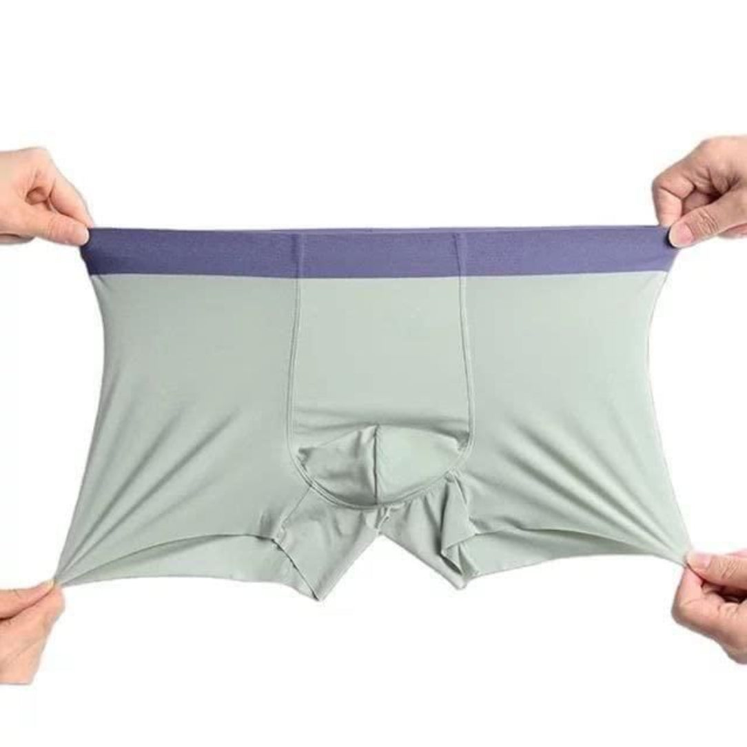 Light gray boxer briefs with purple waistband held by two hands on a white background