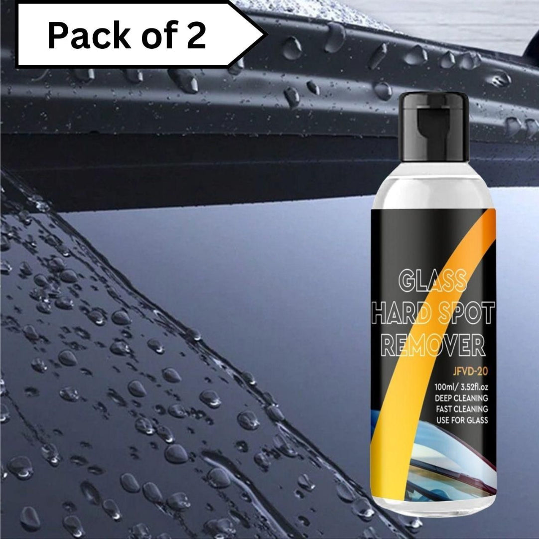 A bottle of Car Glass Oil Film Cleaner with a label that reads 'HARD SPOT REMOVER'. The background shows water droplets on car glass.