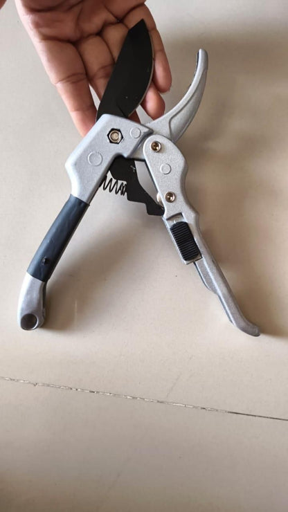 Garden pruner held by a hand on a beige background