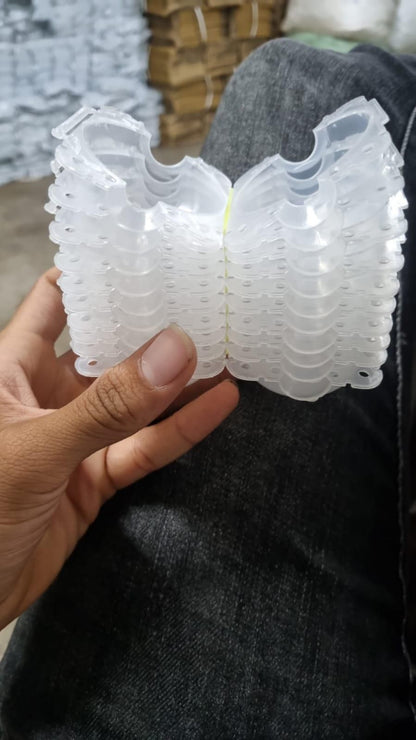 Hand holding a small white plastic object against a blurred background