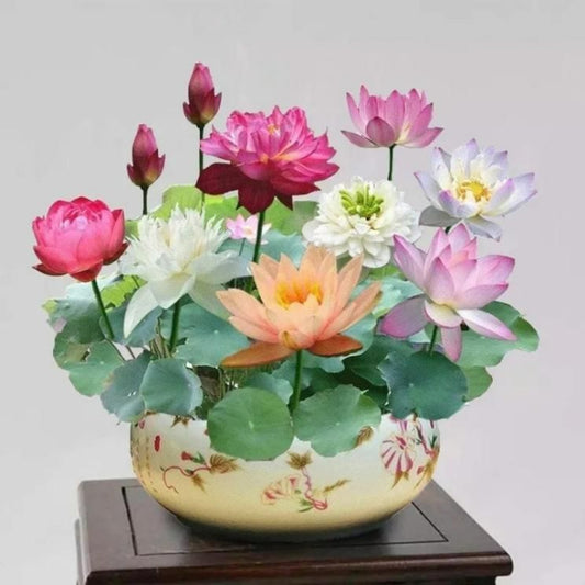 Decorative pot with colorful artificial flowers on a wooden surface