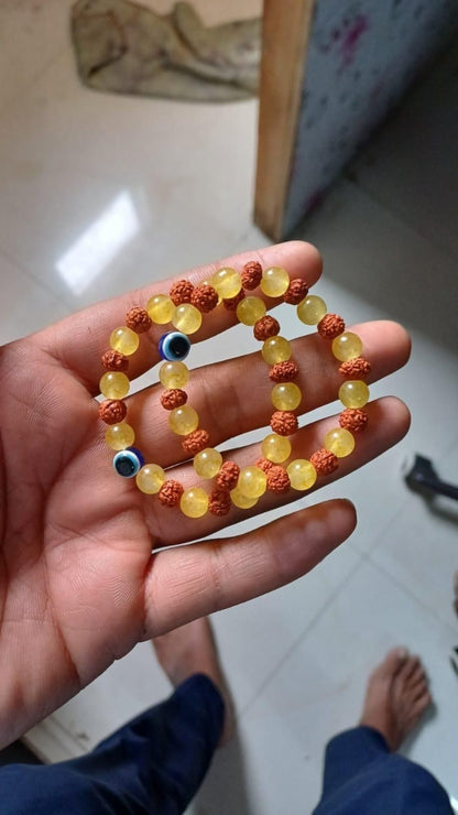 Hand holding a beaded bracelet with colorful beads on a tiled floor background