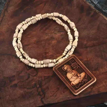 Beaded necklace with a Buddha pendant on a wooden surface