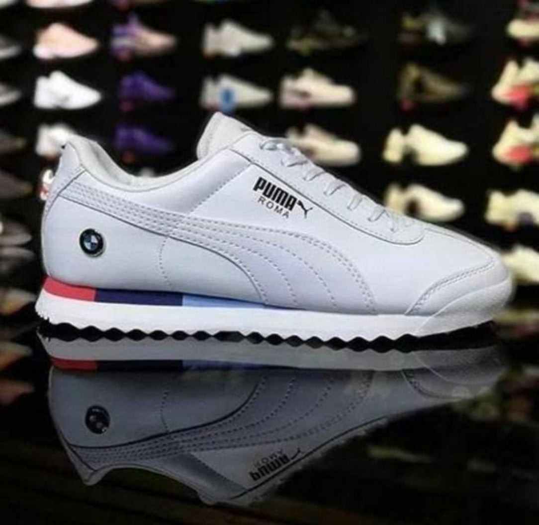 White Puma sneaker with colorful accents on a reflective surface.