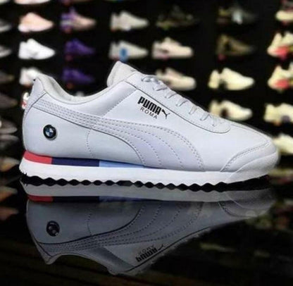 White Puma sneaker with colorful accents on a reflective surface.