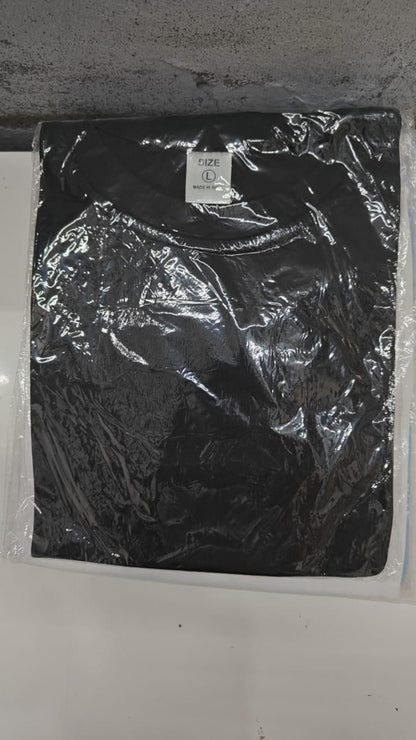 Black t-shirt with a brand logo in clear plastic packaging on a white surface.