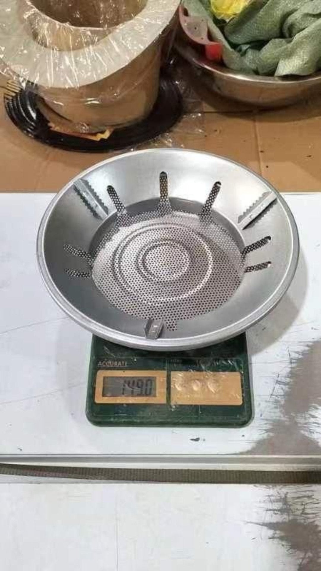 Metallic stove top on a digital scale with a wooden surface in the background