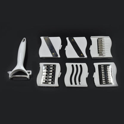 Set of white kitchen tools with interchangeable blades on a black background