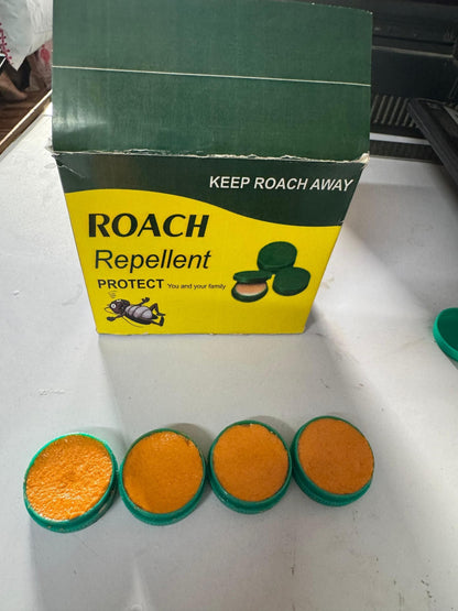 Roach repellent packaging with four orange and green discs on a white surface.