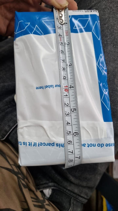 Box of dental floss with a ruler on top, held by a person.