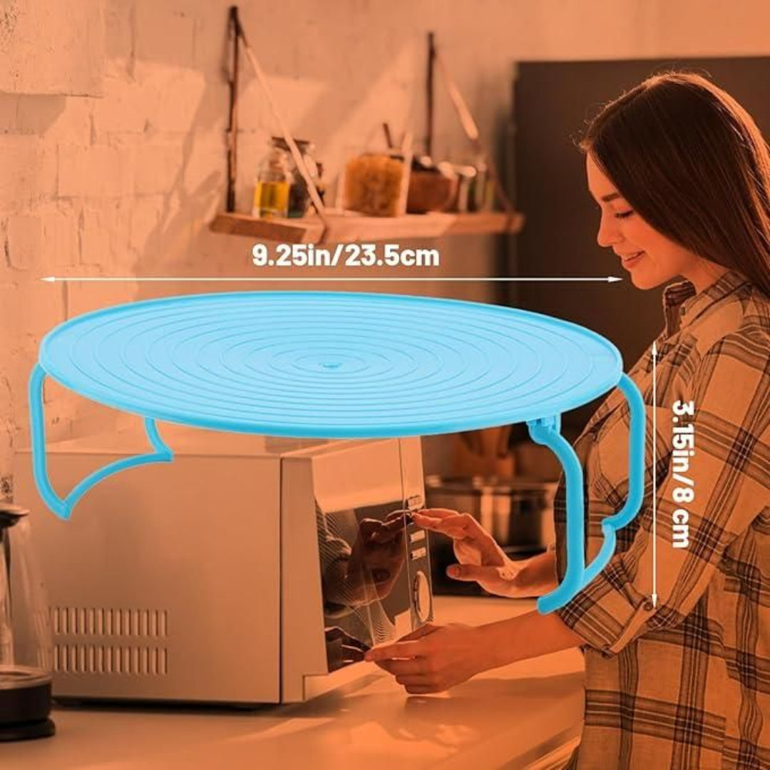 Woman using a small round table next to a microwave in a kitchen.