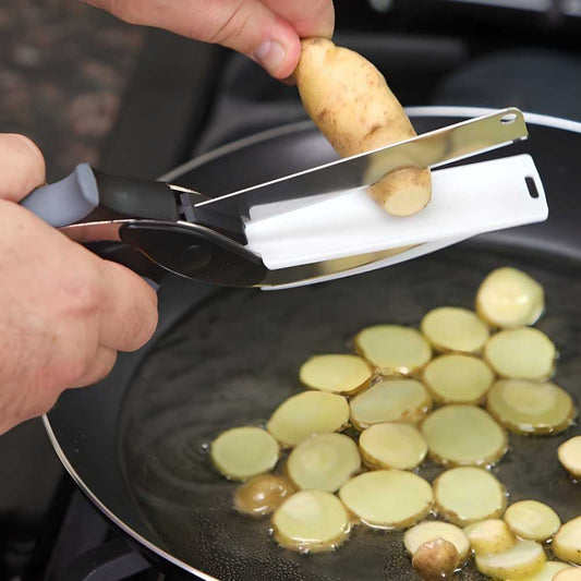 Person using a potato peeler to slice potatoes into a frying pan.