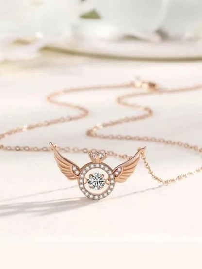Rose gold necklace with a heart and wing design on a white background