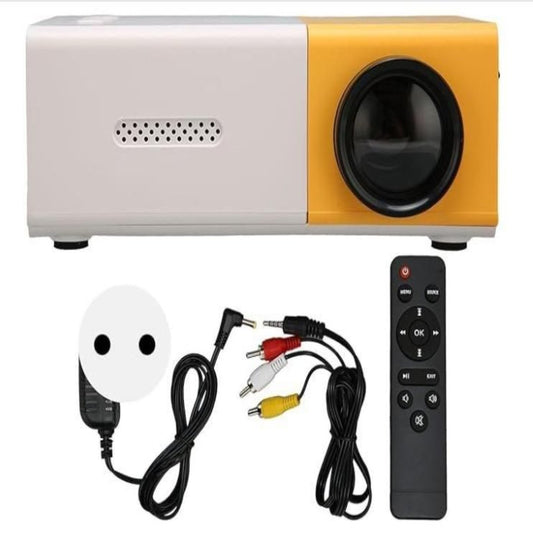 A portable mini projector with white and yellow coloring, accompanied by a remote control and cables. The projector has a dome-shaped screen and a speaker grill visible on one side.