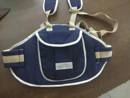 Navy blue baby carrier with straps on a brown surface