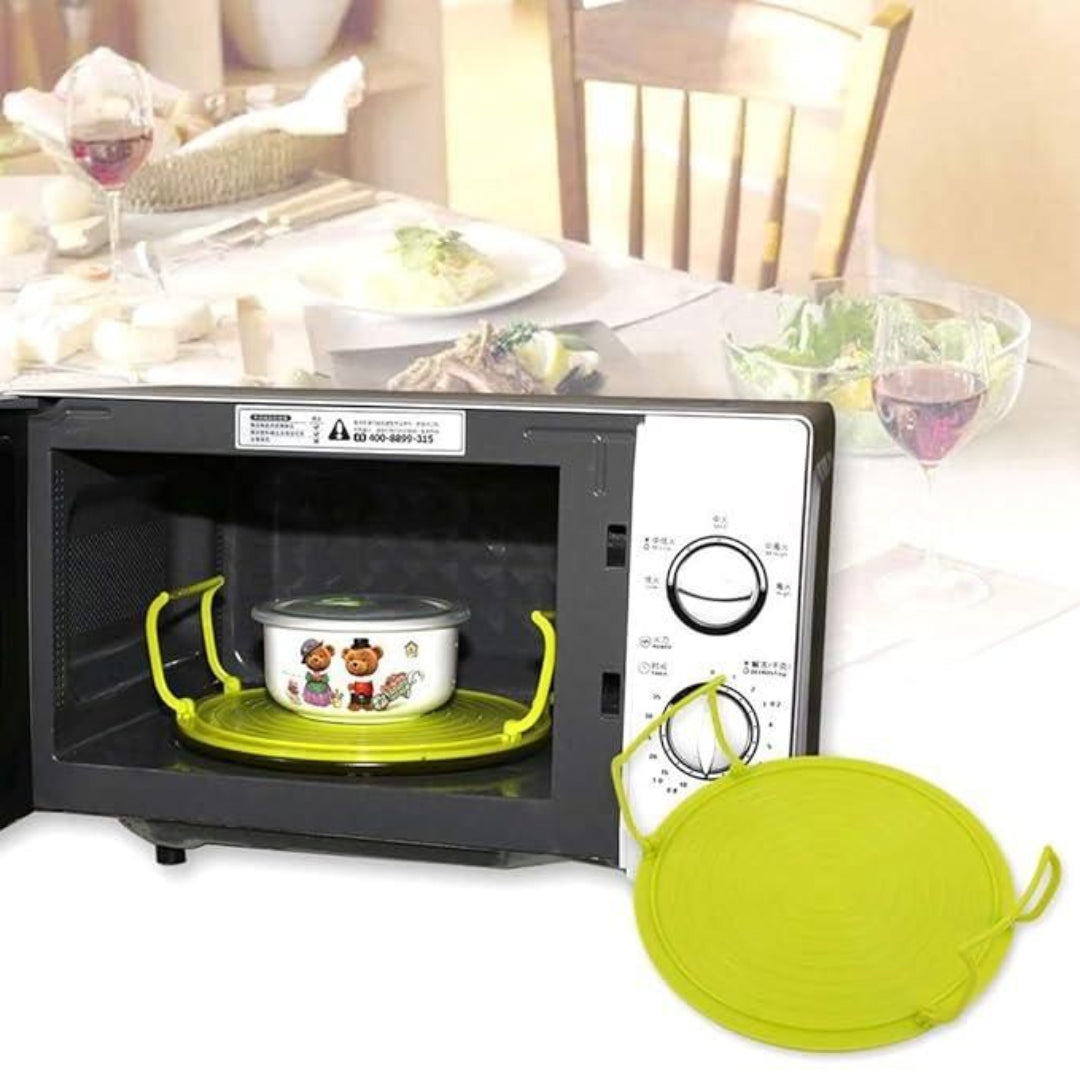 Green silicone lid on a microwave with a table and chairs in the background