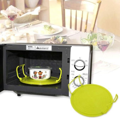 Green silicone lid on a microwave with a table and chairs in the background